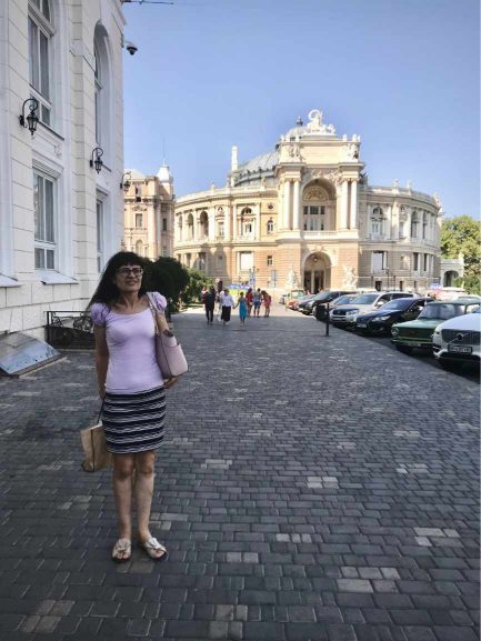 Oleksandra standing on a  cobblestone sidewalk in Ukraine