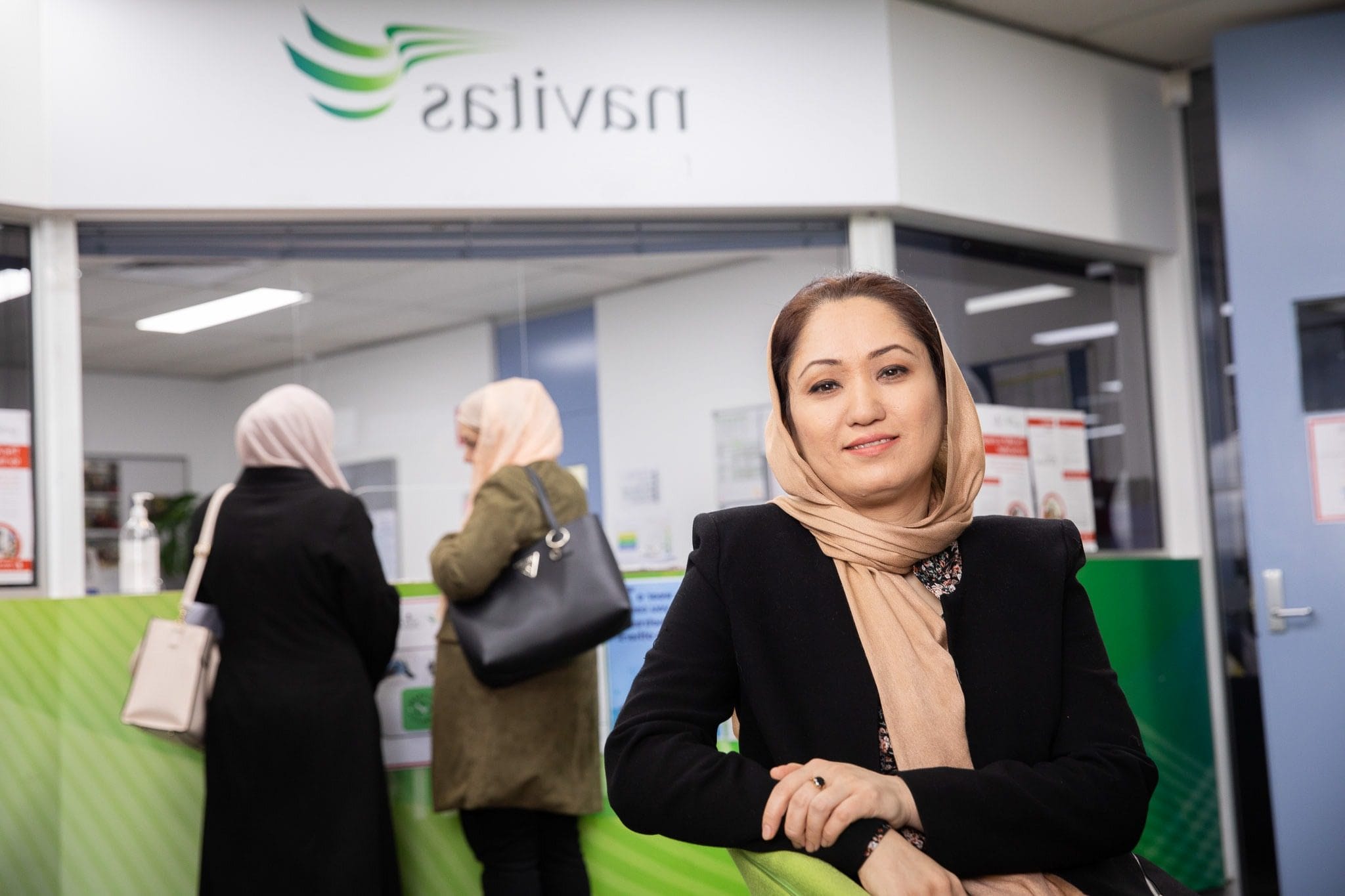 Woman wearing hijab sitting at Navitas reception