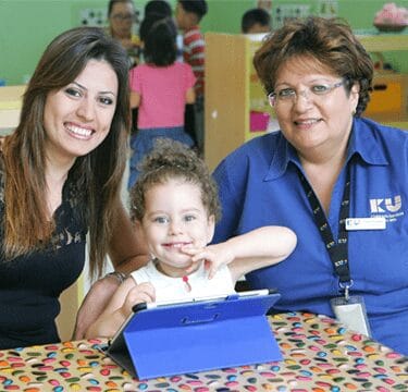 Navitas employee and woman sitting next to a child