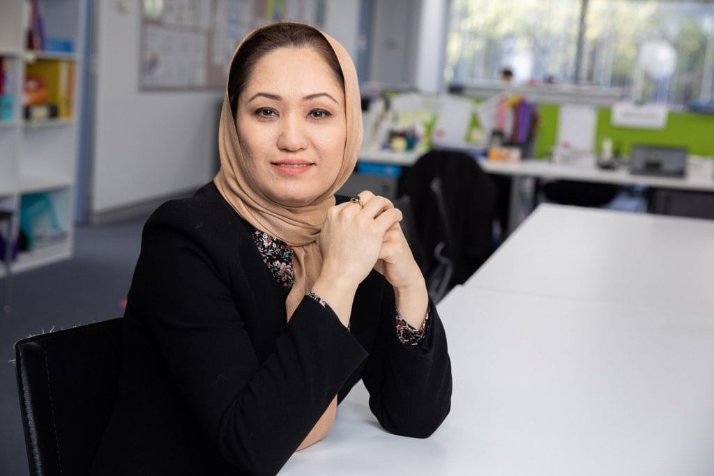 Woman wearing hijab sitting at desk.